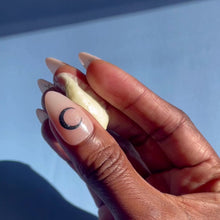 Load and play video in Gallery viewer, A hand is rubbing creamy whipped body butter back and forth across their fingers on a baby blue background.